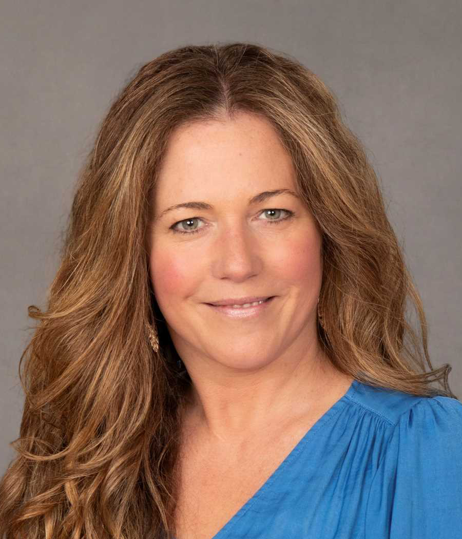 Smiling woman with long brown hair in bright blue shirt