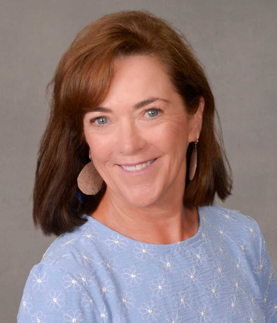 Smiling woman with brown hair in light blue sweater