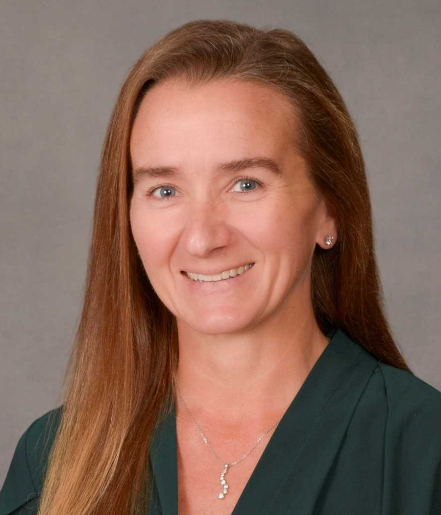 Smiling woman with long brown hair wearing a dark green shirt